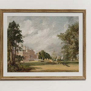 May include: A framed watercolour painting depicting a large, pink mansion with a green lawn and trees in the foreground. The sky is cloudy and blue. There are peacocks in the lawn.