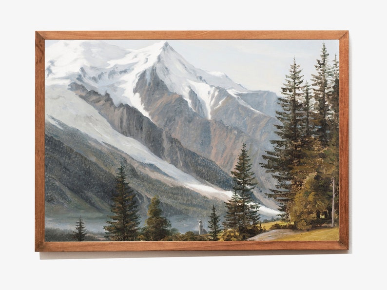 May include: A framed painting depicting a snow-capped mountain range with a valley in the foreground. The mountain peaks are covered in white snow and the valley is filled with green trees. The painting is framed in a brown wooden frame.