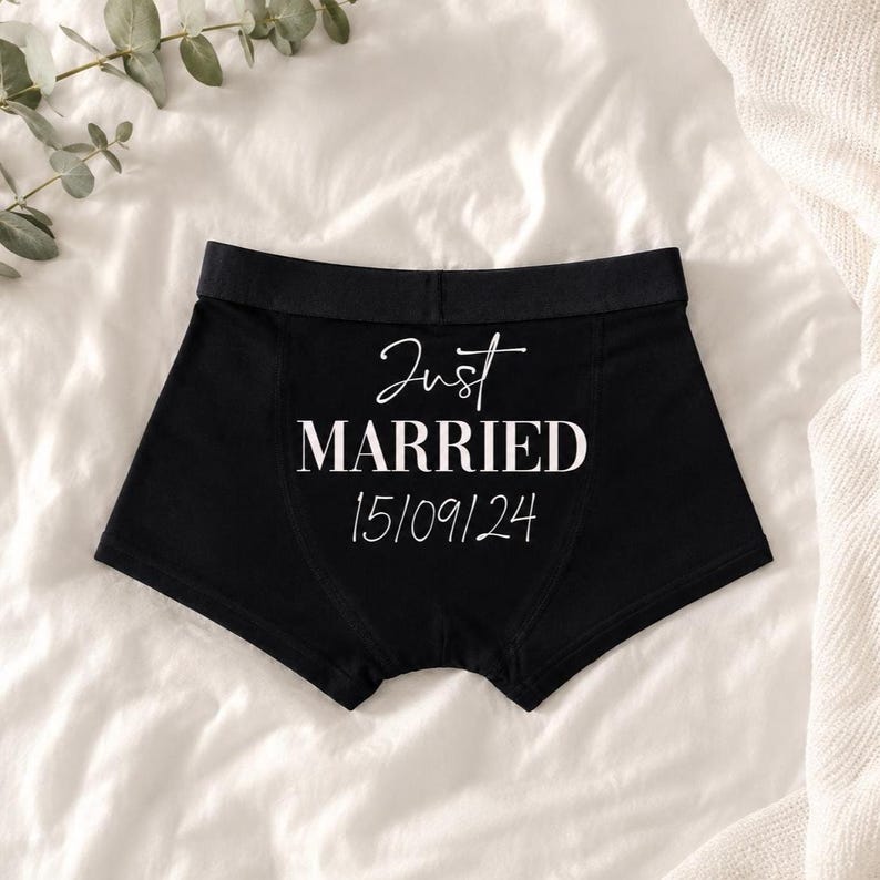 May include: Black boxer briefs featuring the white text Just MARRIED and the date 15/09/24 printed on the front. The garment has a solid black waistband and a fitted silhouette, presented as a clean and simple piece of apparel.