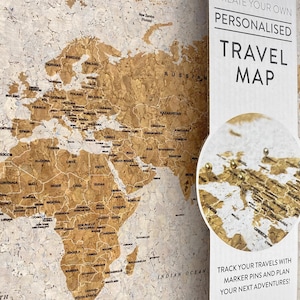 May include: A corkboard world map with gold push pins marking locations. The map is surrounded by a white border with the text "Create Your Own Personalised Travel Map" and "Track Your Travels With Marker Pins And Plan Your Next Adventures!"