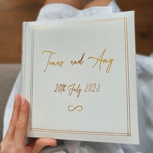 Luxury wedding photo album in white colour with cold lining on the cover. Personalised with your names and wedding date in matching gold text colour. Slip album for 200 photos , size of photos is  4 x 6 inch, 10 x 15 cm
