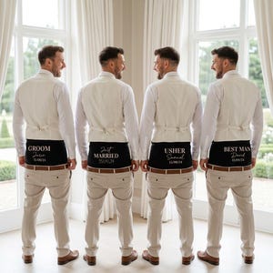 May include: Four individuals wearing white long-sleeved shirts, cream vests, and beige trousers. Each person wears black underwear visible above the waistband with white text: GROOM Jason 15/09/24, Just MARRIED 15/09/24, USHER Samual 15/09/24, and BEST MAN David 13/09/24.