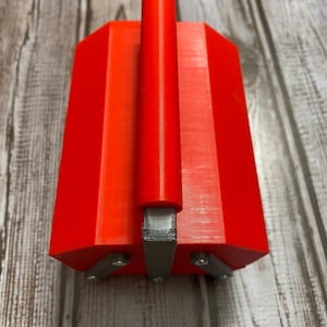 May include: A bright orange toolbox with a silver handle. The toolbox has a rectangular shape with rounded edges.