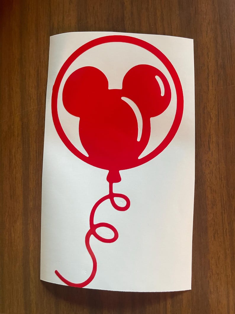 May include: A red Mickey Mouse balloon sticker on a white background. The balloon is inside a red circle and has a curly red string. The sticker is on a white background.