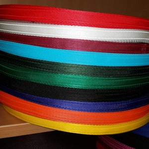 Może przedstawiać: Stos kolorowych taśm, w tym czerwonej, białej, bordowej, turkusowej, zielonej, czarnej, granatowej, pomarańczowej i żółtej.