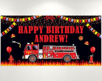 May include: A banner with a black background featuring a red fire truck, flames, and the text "HAPPY BIRTHDAY ANDREW!". The banner includes fire helmets, a fire hydrant, and balloons. Colorful bunting and confetti decorate the top.