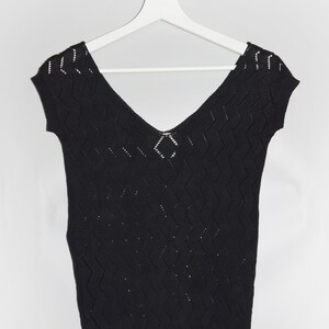 Può includere: Top in maglia nera con motivo a rombi e scollo a V. Il top ha maniche corte e una vestibilità ampia.