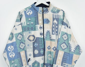 May include: A blue, green, and beige patterned jacket with a zipper closure. The jacket has a stand-up collar and long sleeves.
