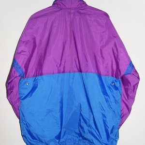 May include: A purple and blue windbreaker jacket with a zip fastening and a drawstring at the bottom.