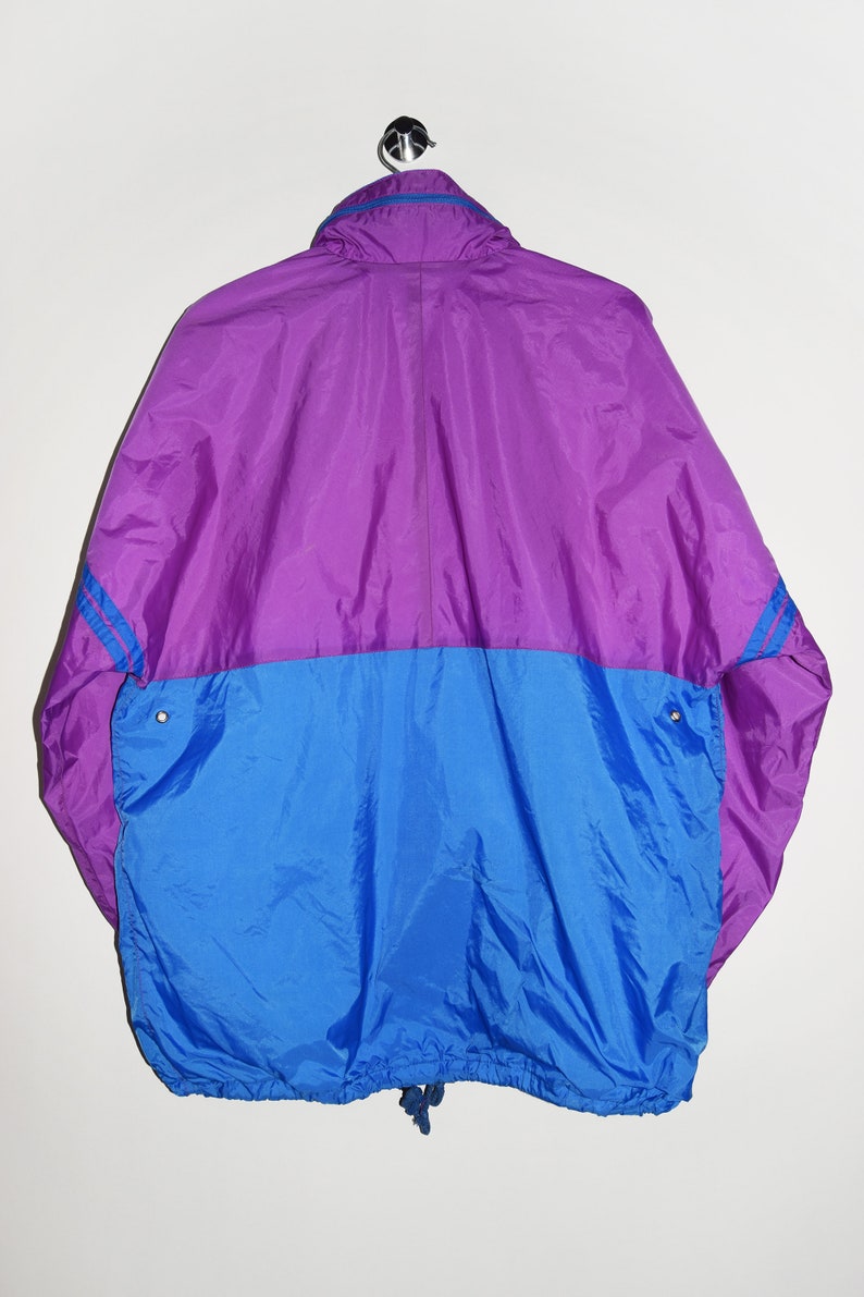 May include: A purple and blue windbreaker jacket with a zip fastening and a drawstring at the bottom.