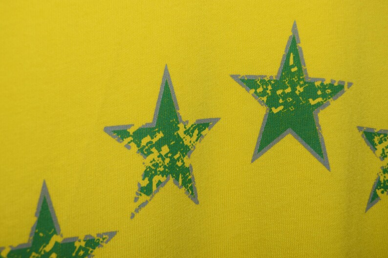 May include: Yellow fabric with a green and gray star pattern.