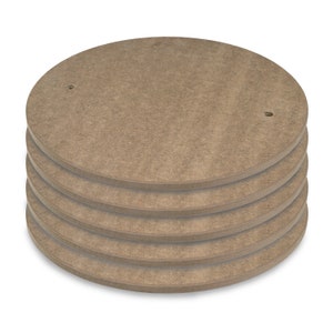 May include: A stack of five round, brown, wooden discs with holes in the center. The discs are stacked on top of each other.