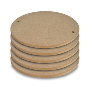 May include: A stack of six round, unfinished wood circles with a small hole in the center of each circle.