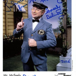 May include: A color photograph of Mr. McFeely from Mister Rogers' Neighborhood. He wears a blue uniform with a "Speedy Delivery" patch, a black cap, and glasses. The image includes handwritten signatures and the text "Mister Rogers' Neighborhood."