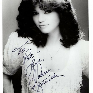 May include: Black and white photograph of a woman with long, layered hair. She is wearing a white, crocheted top and a silver necklace. The photo is signed "To Pat - Love, Valerie Bertinelli."