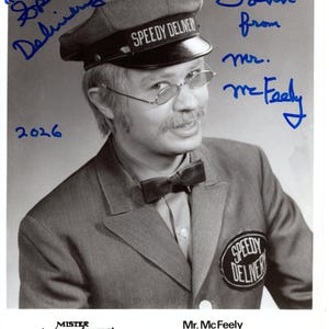May include: Black and white photograph of Mr. McFeely from Mister Rogers' Neighborhood. He wears a gray uniform with a "Speedy Delivery" patch and cap. The image includes handwritten text: "Speedy Delivery!" and "John from mr. McFeely."