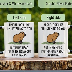 Peut inclure: Mug en c&eacute;ramique blanche avec une anse et un bord noirs, avec une illustration de capybara et le texte "I MIGHT LOOK LIKE I'M LISTENING TO YOU BUT IN MY HEAD I'M THINKING ABOUT CAPYBARAS." Passe au lave-vaisselle et au micro-ondes.