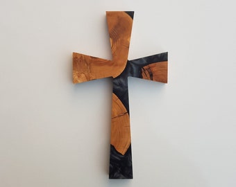 Può includere: Una croce di legno con intarsi in resina nera e grigia. La croce è realizzata in legno naturale con una venatura unica.