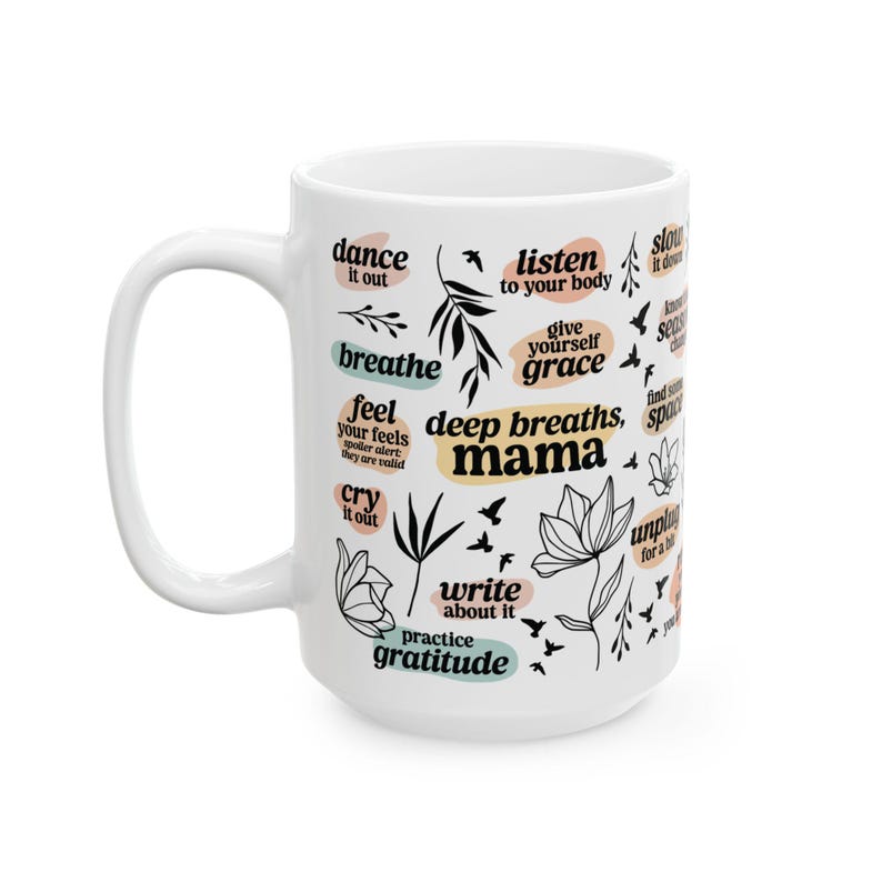 May include: White ceramic mug with black and teal text and illustrations. The mug features phrases like "breathe," "listen to your body," and "deep breaths, mama." Floral and bird illustrations are also included.