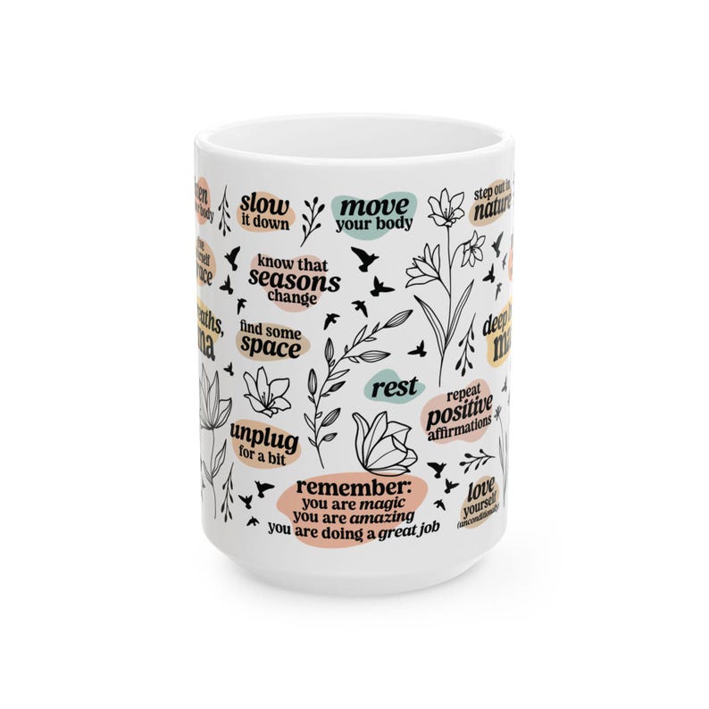 May include: White ceramic mug with black text and floral illustrations. The mug features phrases like "slow it down," "move your body," and "remember: you are magic." The design includes birds and botanical elements.