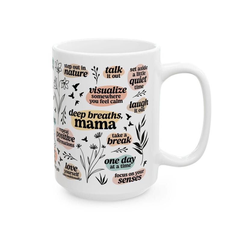 May include: White ceramic mug with black and pastel-colored text and floral illustrations. The mug features phrases like "deep breaths, mama," "take a break," and "love yourself." A perfect gift for anyone.