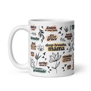 May include: White ceramic mug with black botanical illustrations and inspirational phrases like "deep breaths, mama" and "practice gratitude." The mug also features floral and bird designs, with text in various colors.