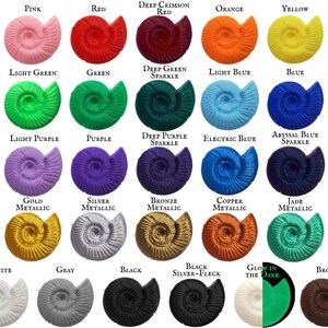 3D printed shells show examples of each of the 26 available colors: pink, red, orange, yellow, shades of green, shades of blue, shades of purple, glow in the dark, gold, silver, bronze, copper, jade, black, black silver-fleck, gray, white, and brown.