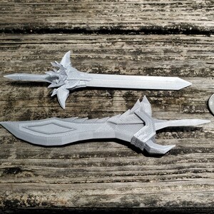Small but detailed 3D printed swords based on designs from a video game sit next to a quarter to demonstrate their size. Similar custom 3D printing projects can be commissioned from the Nautolith Crafts shop.