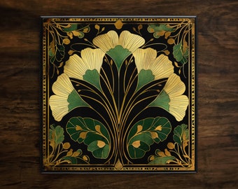 May include: A black square tile with a gold and green floral design. The design features stylized leaves and flowers with a repeating pattern.