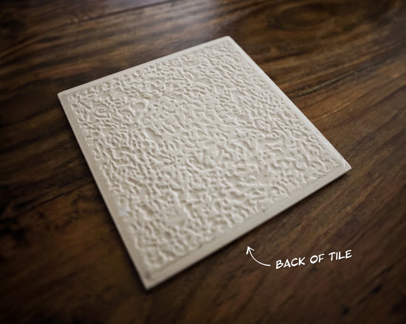 Puede incluir: La parte posterior de un azulejo de cer&aacute;mica blanco con una superficie texturizada. El azulejo es rectangular y tiene una textura rugosa y desigual. El texto "BACK OF TILE" est&aacute; escrito en la esquina inferior derecha del azulejo.