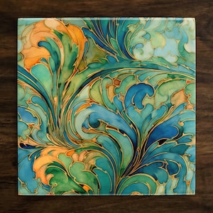 May include: A square glass cutting board with a colorful abstract design. The design features swirling blue, green, and orange shapes with gold accents.