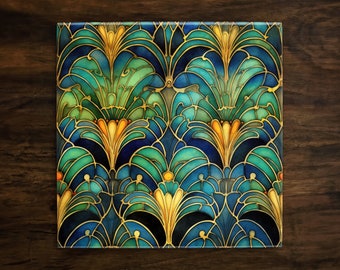 May include: A square tile with a repeating pattern of stylized floral designs in shades of blue, green, and gold. The tile has a glossy finish and a slightly raised design.