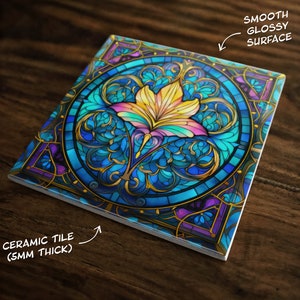 May include: A square ceramic tile with a colorful stained glass design featuring a stylized flower with blue, yellow, and purple hues. The tile has a smooth, glossy surface and is 5mm thick.