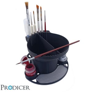 Könnte beinhalten: Ein schwarzer Plastik-Pinselhalter mit mehreren Fächern zum Verstauen von Pinseln und Farbflaschen. Der Halter hat einen runden Boden und einen zylindrischen oberen Teil mit einem Rand. Es befinden sich mehrere Pinsel im Halter, darunter ein roter Pinsel, ein weißer Pinsel und ein brauner Pinsel. Es befindet sich auch eine kleine Farbflasche im Halter.