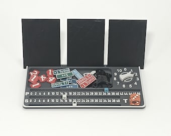 May include: A black and gray game organizer with a dial, dice, and various game tokens. The organizer has a series of number markers and three black card holders. The tokens are red, blue, and white.