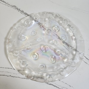 May include: A clear glass serving dish with a raised, textured rim and a scalloped edge. The dish has a iridescent finish and is divided into three sections.