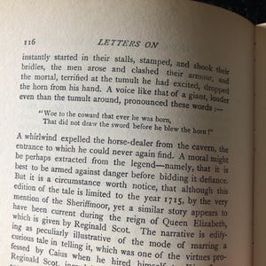 Op de afbeelding: Open boek met tekst op verouderd papier. Paginanummer 116 is zichtbaar, samen met de titel "LETTERS ON". De tekst beschrijft een sc&egrave;ne met mannen, harnassen en een hoorn en bevat een citaat.