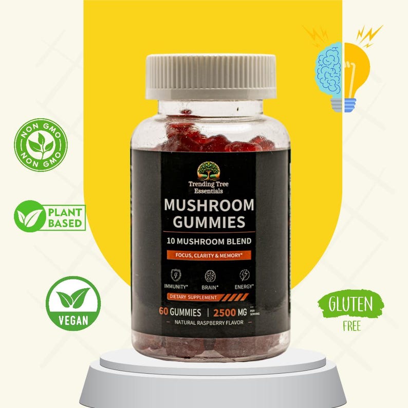 May include: A clear plastic bottle containing red mushroom gummies. The label states "Mushroom Gummies" with "10 Mushroom Blend" and "Focus, Clarity & Memory." Additional text includes "Immunity," "Brain," and "Energy." The bottle sits on a white plinth.