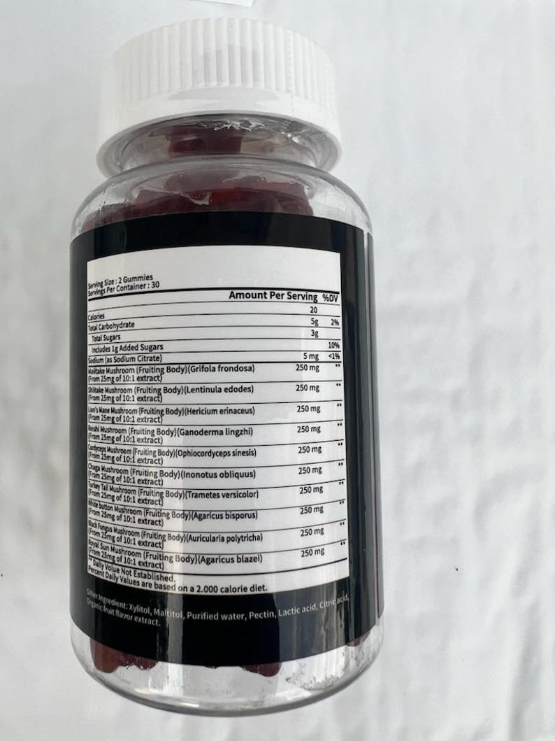 May include: A clear plastic bottle containing red gummies. The bottle has a white lid and a black label detailing nutritional information, such as calories, carbohydrates, and mushroom extracts. The label also states the serving size and number of servings.