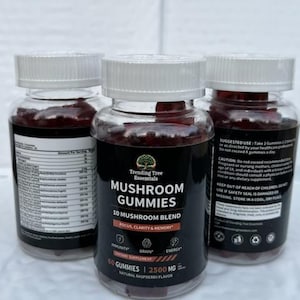 May include: Three clear plastic bottles of mushroom gummies with white lids. The labels read "Trending Tree Essentials MUSHROOM GUMMIES 10 MUSHROOM BLEND" and list benefits like focus, clarity, and memory. The gummies are a natural raspberry flavour.