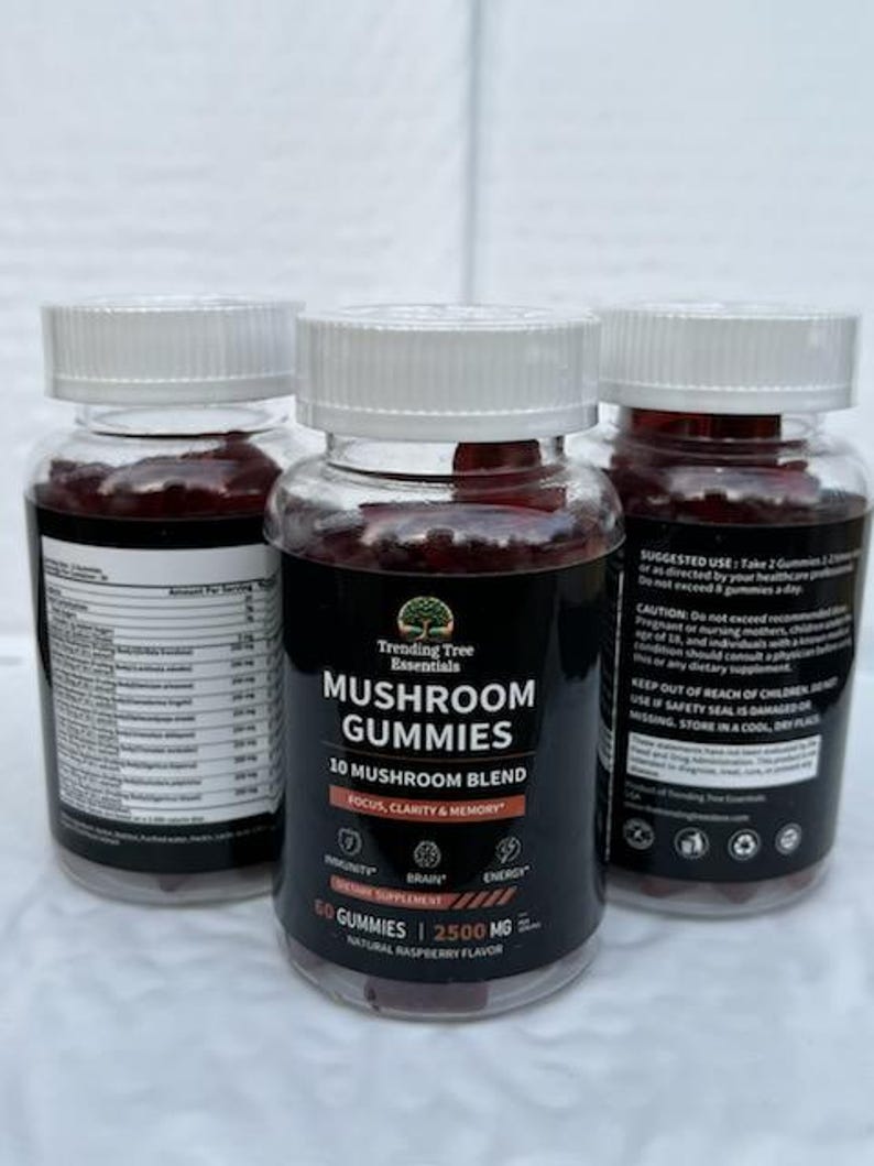 May include: Three clear plastic bottles of mushroom gummies with white lids. The labels read "Trending Tree Essentials MUSHROOM GUMMIES 10 MUSHROOM BLEND" and list benefits like focus, clarity, and memory. The gummies are a natural raspberry flavour.