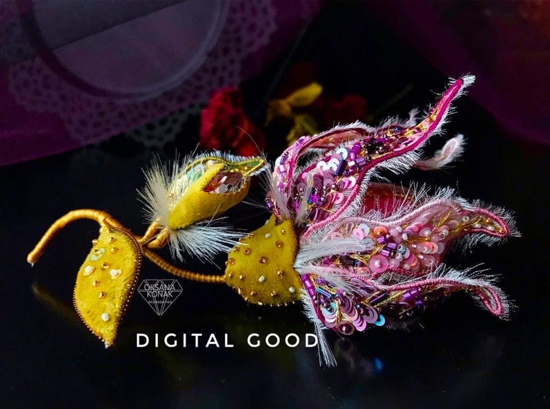 K&ouml;nnte beinhalten: Eine Brosche in Form einer rosa und gelben Blume mit Pailletten und Perlen. Die Blume ist aus Stoff gefertigt und hat ein zartes, verspieltes Design. Die Brosche ist ein digitales Gut.