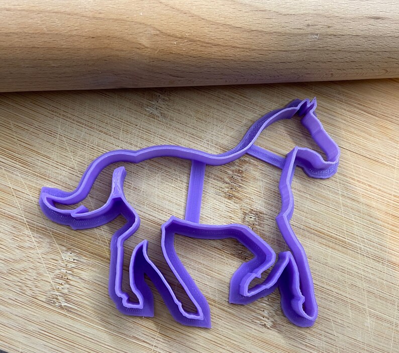 Pu&ograve; includere: Tagliapasta a forma di cavallo in plastica viola. Il tagliapasta ha la forma di un cavallo con la testa e la coda alzate.