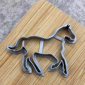 Pu&ograve; includere: Un tagliapasta in metallo argentato a forma di cavallo. Il cavallo &egrave; in una posa di corsa con la testa girata di lato.