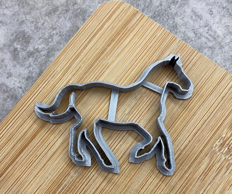 Pu&ograve; includere: Un tagliapasta in metallo argentato a forma di cavallo. Il cavallo &egrave; in una posa di corsa con la testa girata di lato.