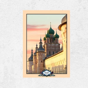 Puede incluir: Una postal vintage con una ilustración colorida de un edificio histórico con cúpulas verdes en forma de cebolla y una torre alta. El edificio está rodeado por un muro de piedra y el cielo es de un rosa y naranja vibrantes.
