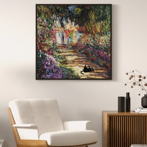 May include: A framed oil painting depicting a garden path leading to a house with a white door. The path is lined with colorful flowers and greenery. A black cat is lying on the path in the foreground.