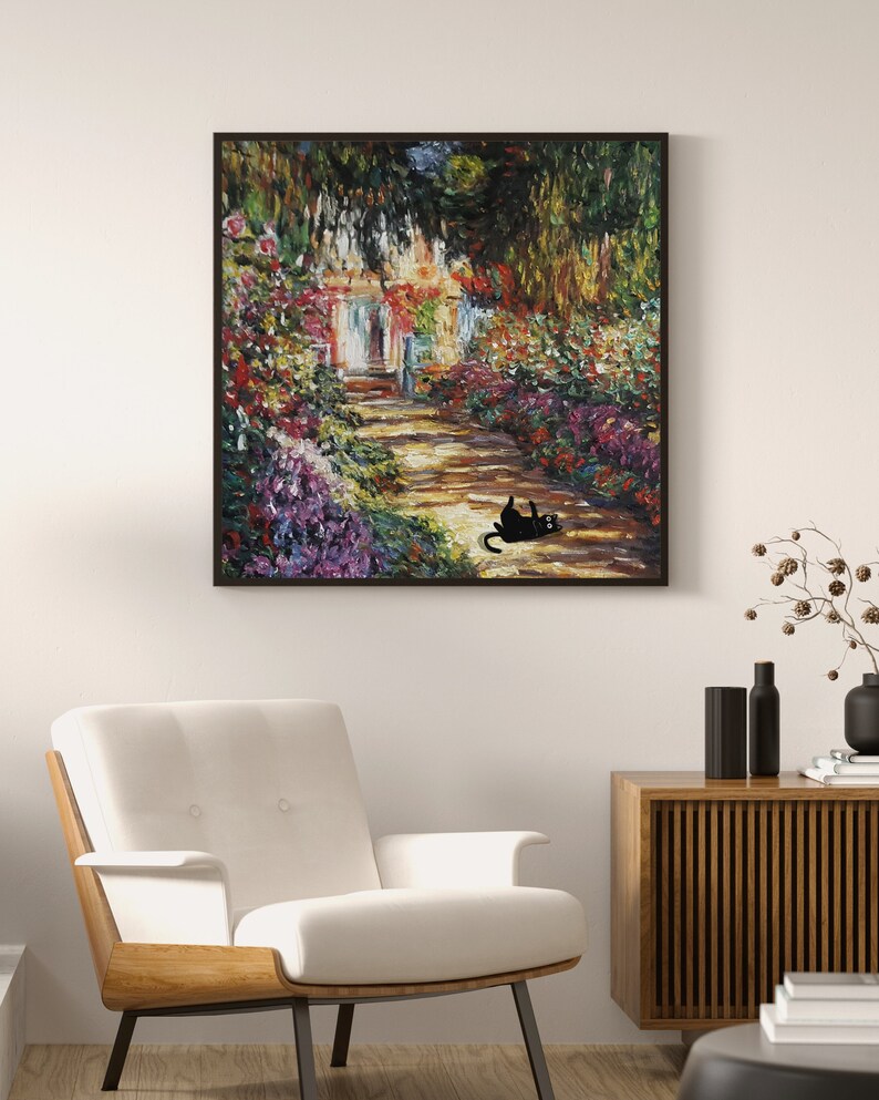 May include: A framed oil painting depicting a garden path leading to a house with a white door. The path is lined with colorful flowers and greenery. A black cat is lying on the path in the foreground.