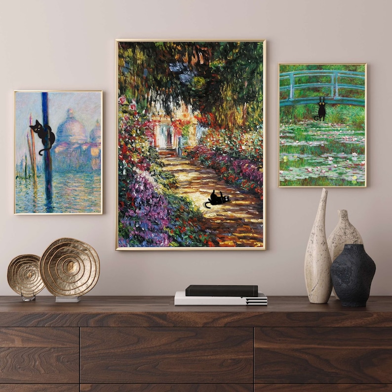May include: Three framed paintings with black cats in different settings. The first painting shows a black cat climbing a pole in a Venetian canal. The second painting shows a black cat lying on a path in a garden with flowers. The third painting shows a black cat walking on a bridge over a pond with water lilies.