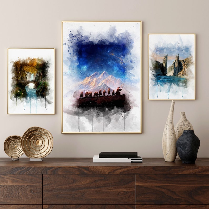 K&ouml;nnte beinhalten: Drei Aquarelle, die Szenen aus Herr der Ringe darstellen. Das erste Bild zeigt eine Gruppe von Hobbits, die durch einen schneebedeckten Gebirgspass wandern. Das zweite Bild zeigt eine Br&uuml;cke &uuml;ber einen Fluss in einem Wald. Das dritte Bild zeigt eine Burg auf einer Klippe mit Blick auf ein Gew&auml;sser.